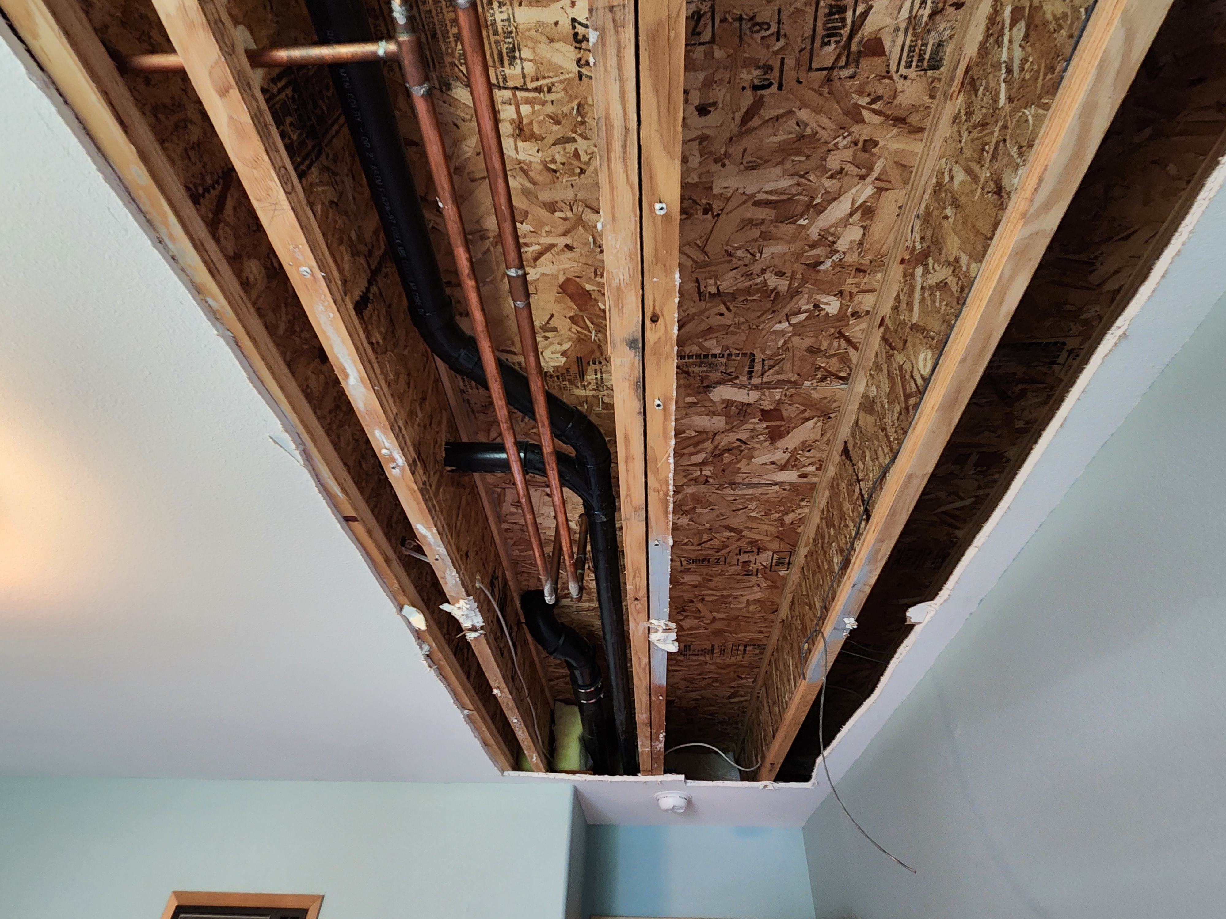 Before drywall repair showing hole from plumbing work in residential ceiling in Kennewick